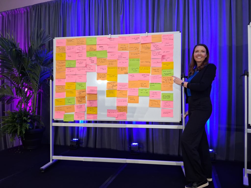 Nicolette Mathey standing near the AtriumX bulletin board during the conference