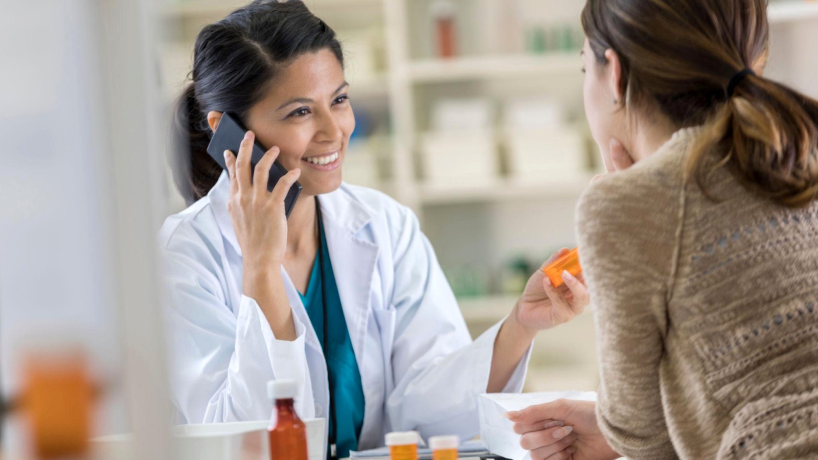Pharmacist discussing cash flow and patient service at the counter